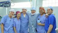 A group of doctors in a row with their arms around each other.